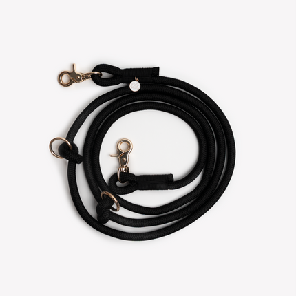 Black dog leash with gold clasp on a white background