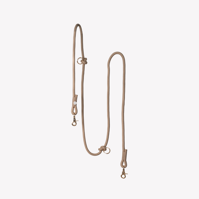Beige leather leash with metal hooks on a white background