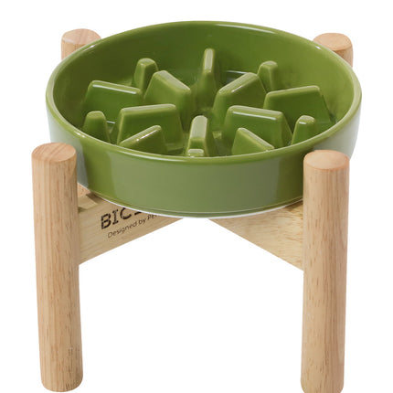 Green dog puzzle feeder with wooden stand on a white background