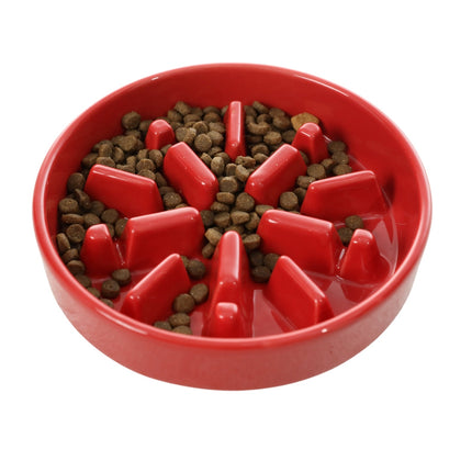 Red slow feeder bowl with dog food on a white background