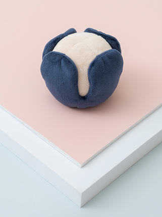 Blue and white plush toy on a pink surface