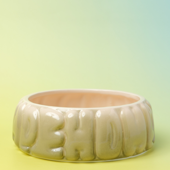 Wide ceramic bowl with embossed text on a gradient yellow background
