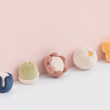 Set of colorful plush toys on a light pink background