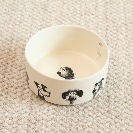 White ceramic bowl with black dog illustrations on a beige carpet