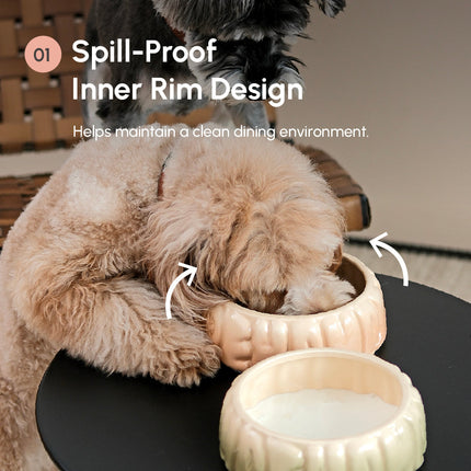 Dog interacting with a spill-proof pet bowl on a table.