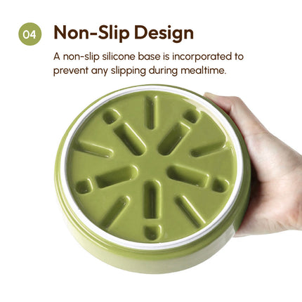 Green pet feeder with non-slip silicone base held by a hand on a white background