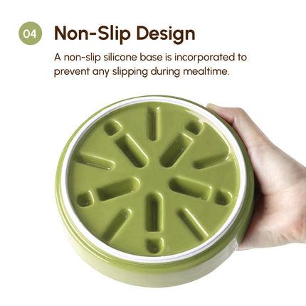 Green pet feeder with non-slip silicone base held by a hand on a white background