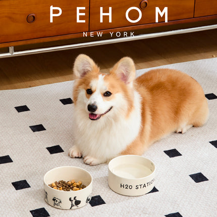 Corgi dog with two bowls on a checkered floor, featuring the brand 'PEHOM New York'.