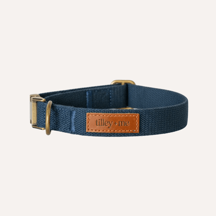 Navy blue dog collar with a brown leather patch on a white background