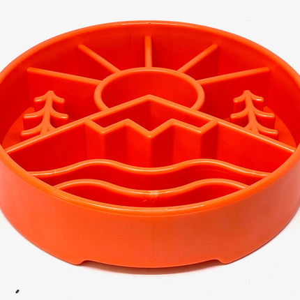 Orange silicone feeding bowl with mountain and sun design on a white background