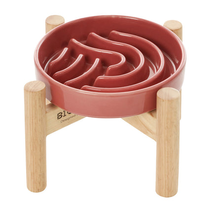 Pink pet bowl with wooden stand on a white background