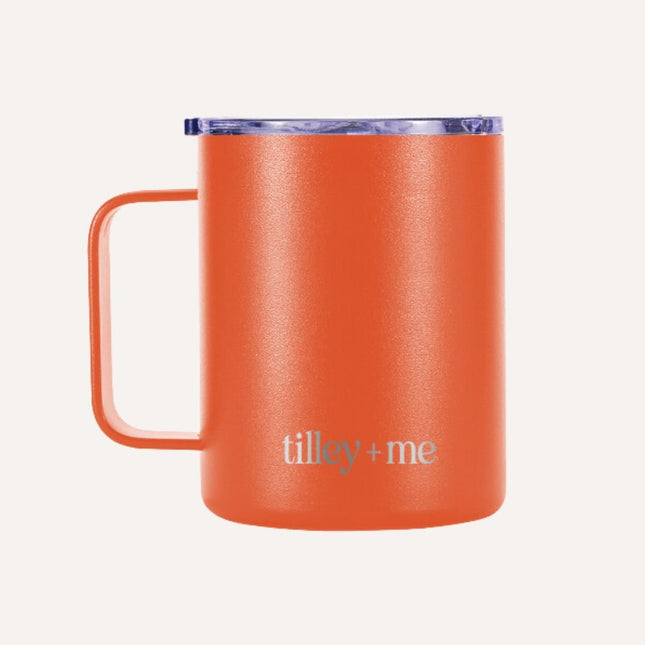Orange mug with 'tilley + me' branding on a white background