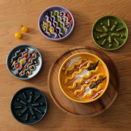 Colorful ceramic bowls with wavy patterns on a wooden surface