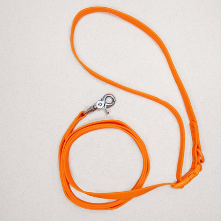 Orange dog leash with a silver clasp on a light gray background