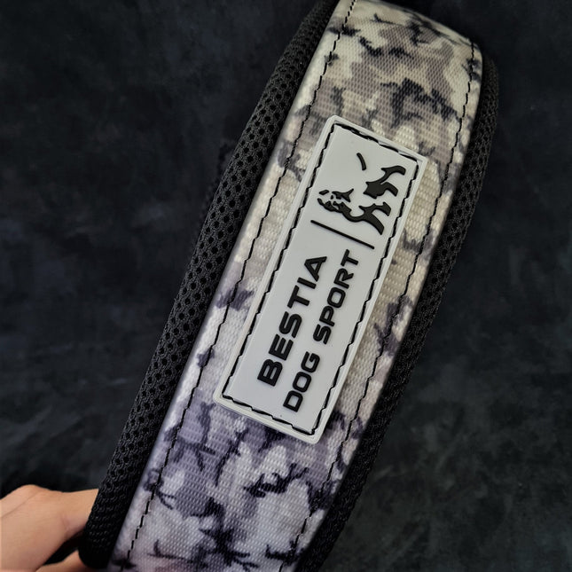 Camouflage dog collar with 'BESTIA DOG SPORT' label on a dark background