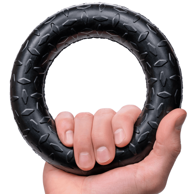 Hand holding a black textured ring against a white background