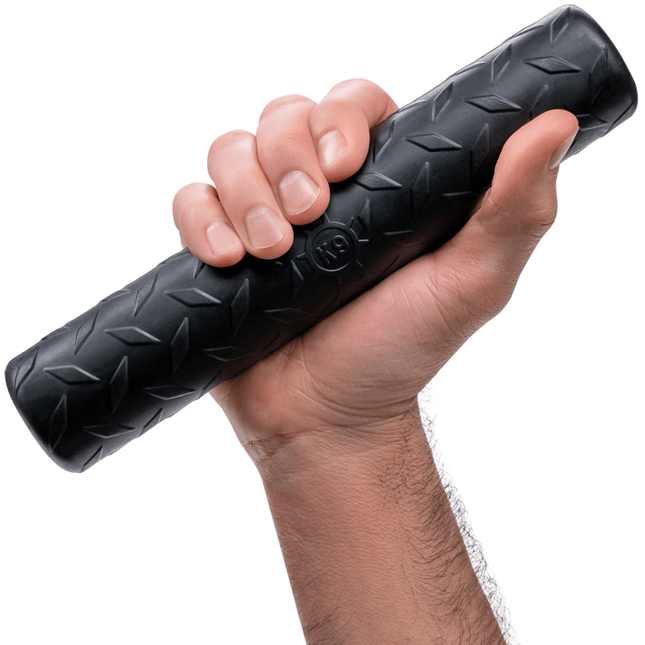 Hand holding a black foam roller with a textured surface on a white background
