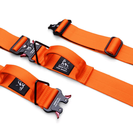 Orange dog harnesses with black buckles on a white background
