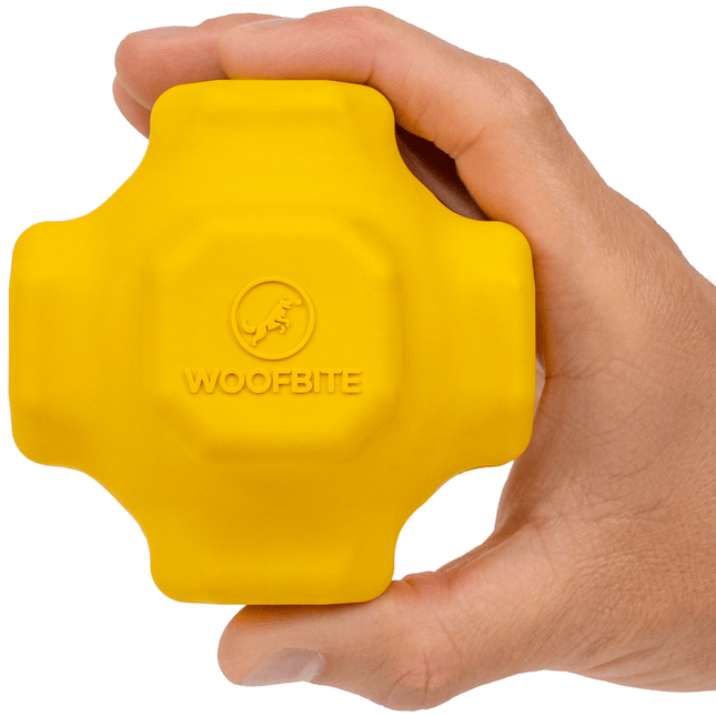 Yellow dog toy with 'WoofBite' branding held in a hand against a white background