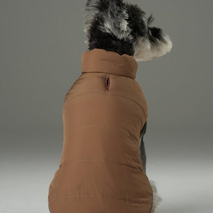 Dog wearing a brown puffer vest on a gray background