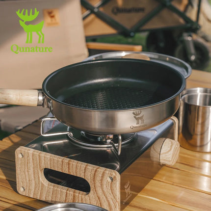 Cooking pan on a portable stove with Qu nature branding in the background