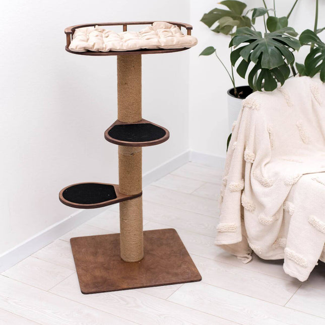 Cat tree with multiple levels on a white floor next to a plant and a white chair.