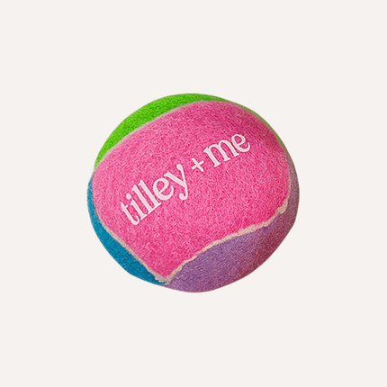 Colorful tennis ball with 'tilley + me' branding on a white background