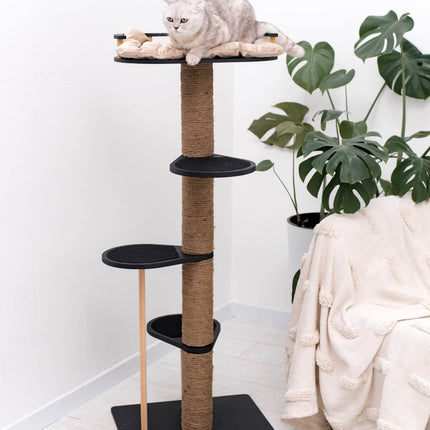 Cat tree with a cat on top in a room with a plant and a chair.